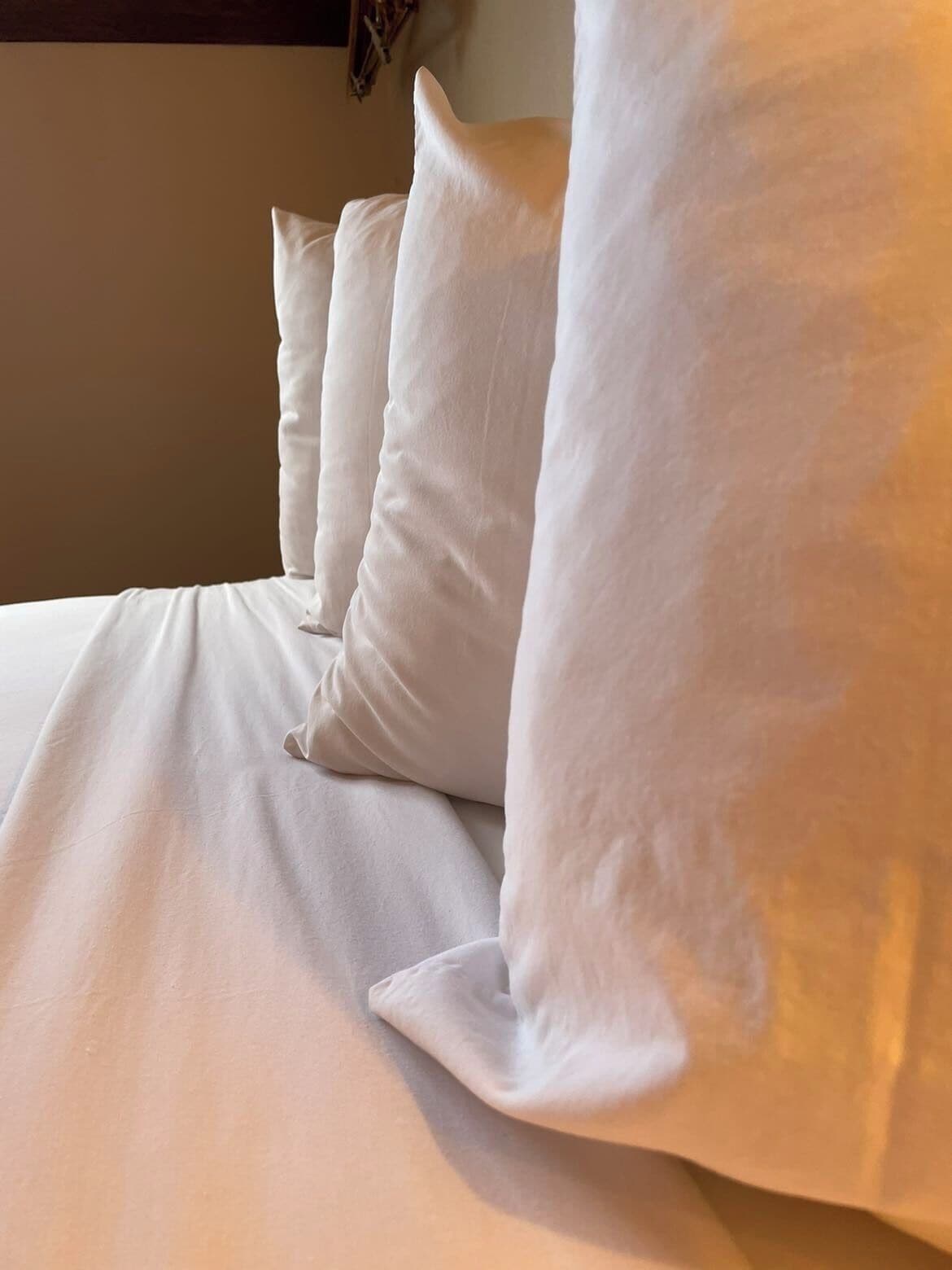 Een bed met wit beddengoed en kussens.