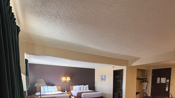 Une chambre d’hôtel avec deux lits, une table à manger et des chaises.
