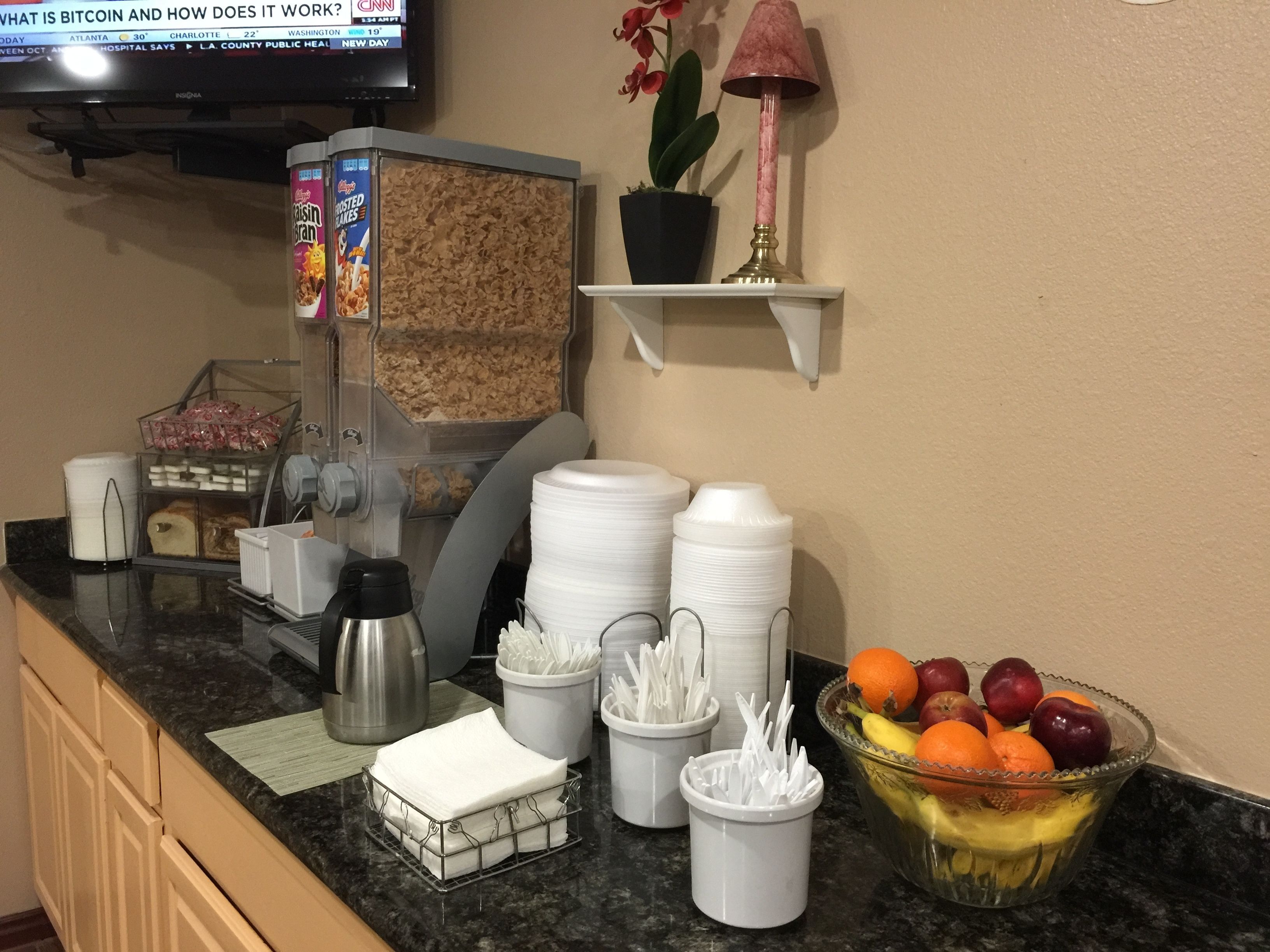 Un buffet pour le petit-déjeuner avec des céréales, du café et des fruits.