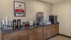 Una encimera de cocina en un hotel con cafeteras, microondas y refrigerador.