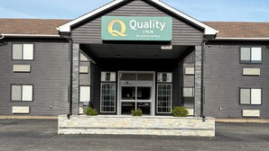A building with a sign reading 'Quality Inn by Choice Hotels' and a stone facade.