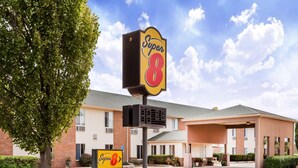 A Super 8 motel with a large sign, a covered parking area, and a brick building. - Super 8 by Wyndham Pekin/Peoria Area (Pekin)