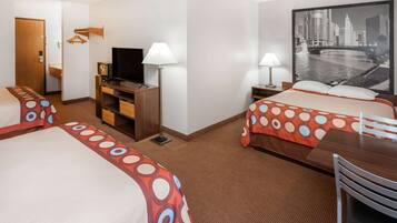 A hotel room with two beds, a television, a desk, and a large cityscape painting on the wall.