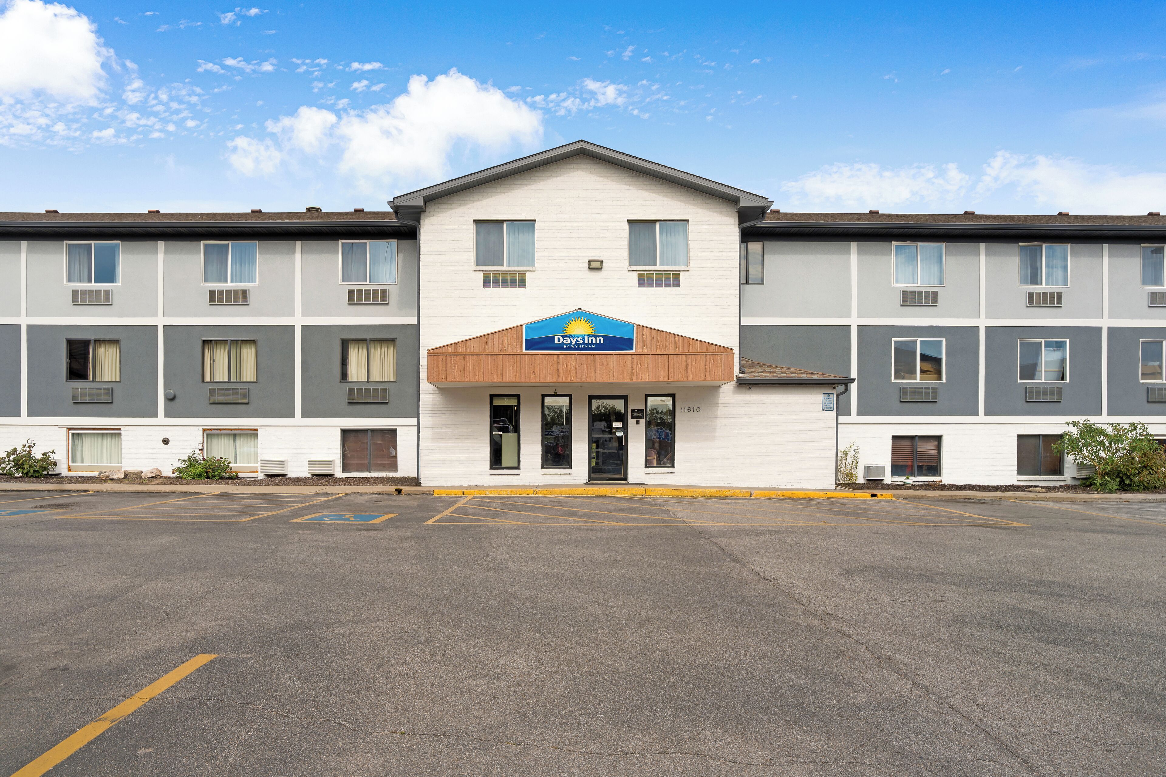 A Days Inn hotel with a flat facade, multiple windows, and a parking lot in front.