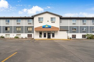 Un hotel Days Inn con fachada plana, múltiples ventanas y un estacionamiento al frente.