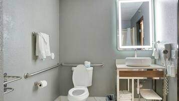A modern bathroom with a toilet, sink, and mirror.