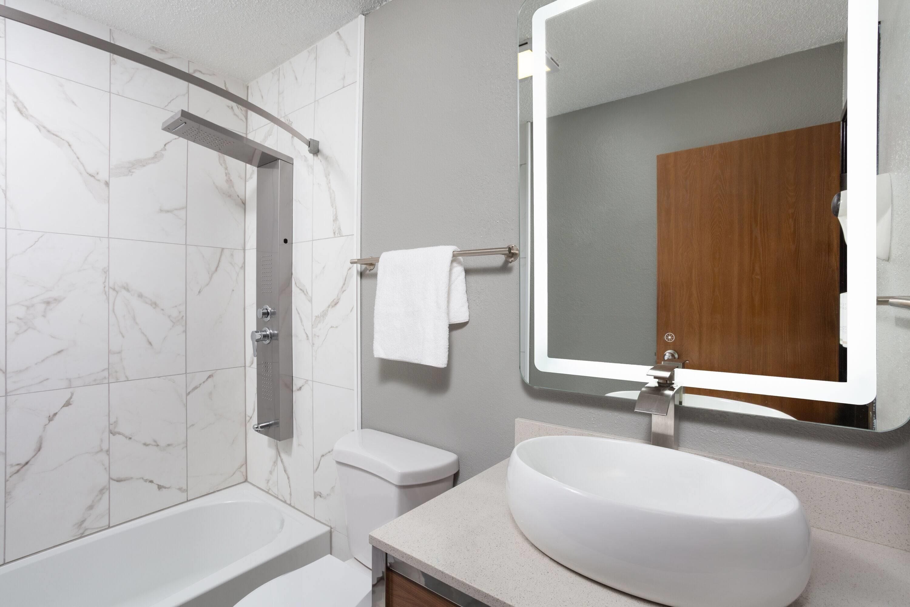A modern bathroom with a bathtub, toilet, and sink.