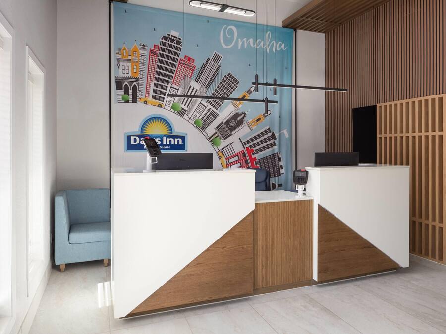 A reception area with a modern design, featuring a white reception desk, a blue sofa, and a cityscape mural on the wall.