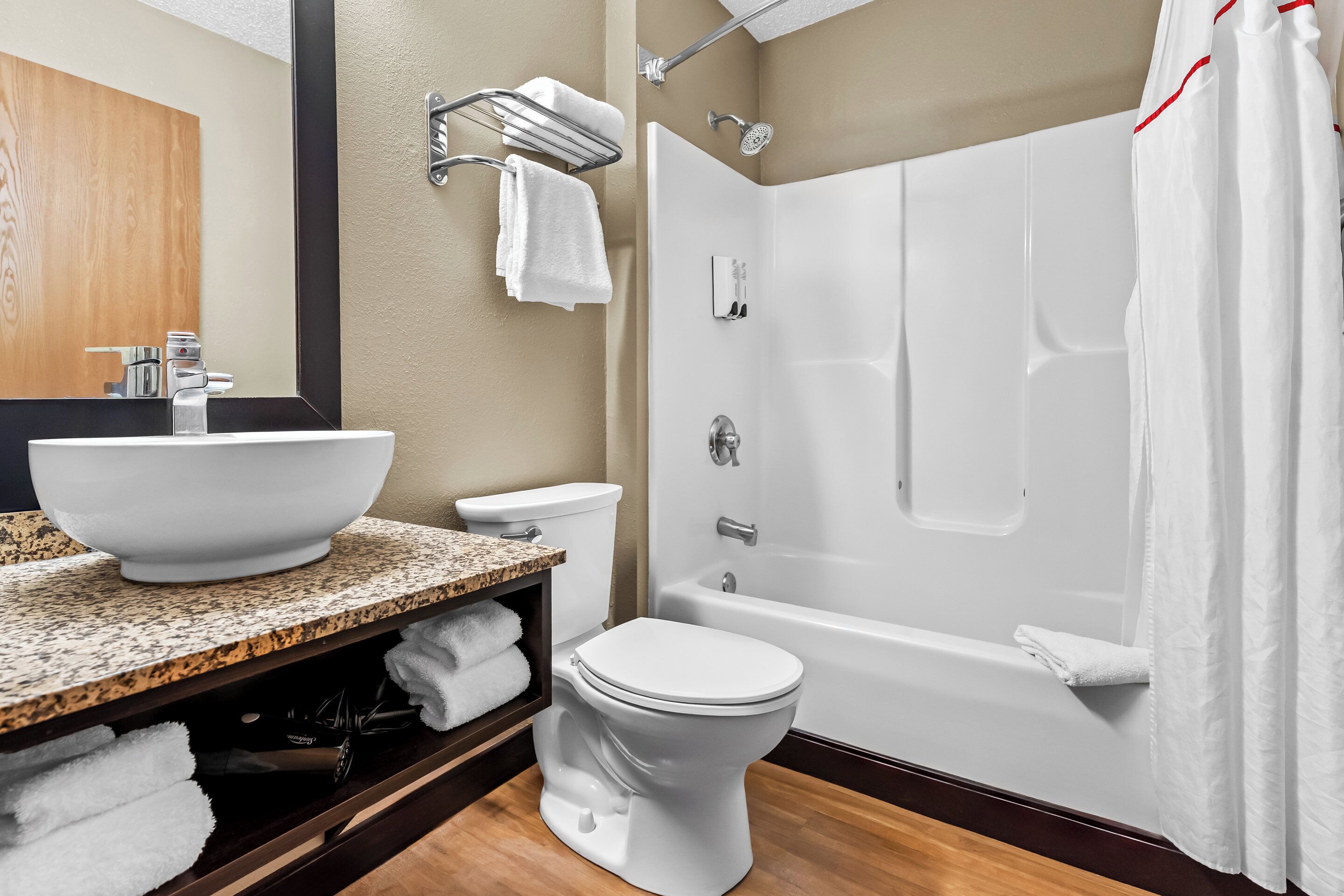 A modern bathroom with a large white sink, a toilet, and a bathtub.
