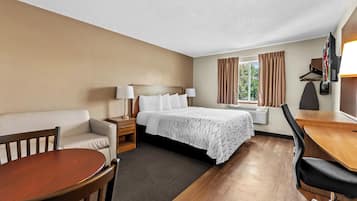 Una habitación de hotel con cama, sofá, escritorio y una silla.