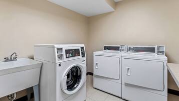 Une buanderie équipée d’un lave-linge, d’un sèche-linge et d’un évier.