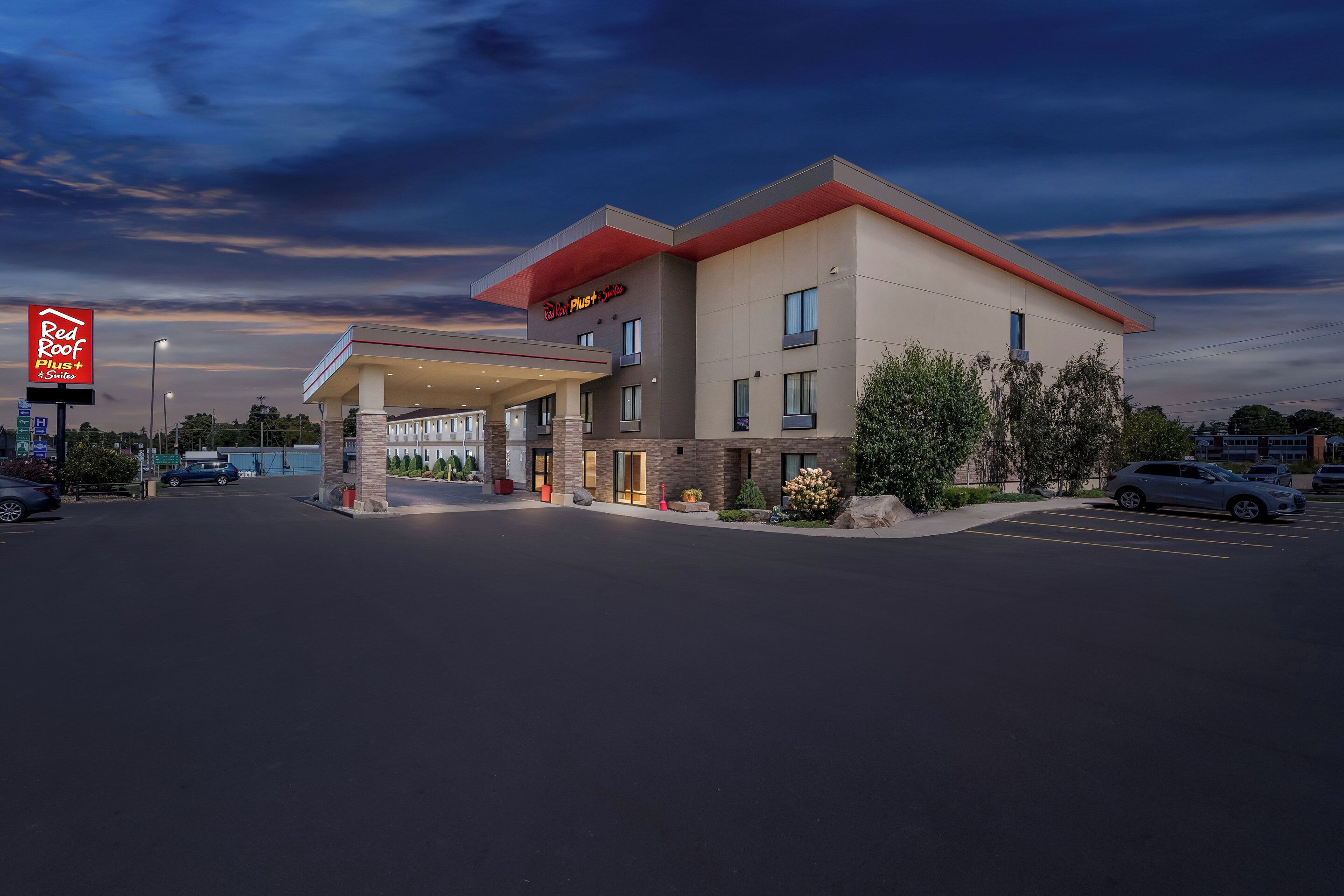 Ett Red Roof Inn-hotell med modern design, utrustat med en ingång under tak och en parkeringsplats.