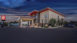 A Red Roof Inn with a modern design, featuring a covered entrance and a parking lot. - Red Roof Inn PLUS+ & Suites Malone (Malone)