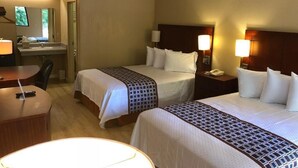 A hotel room with two beds, a desk, and a bathroom. - Inn Between The Hedges (Athens)