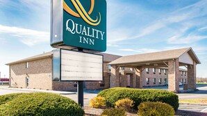 A Quality Inn hotel with a clear sign, a covered parking area, and well-maintained landscaping. - Quality Inn Noblesville - Indianapolis (Noblesville)
