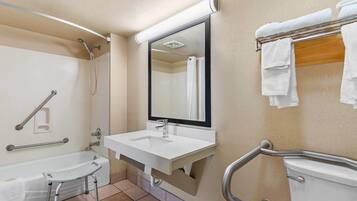 A bathroom with a bathtub, a sink, a mirror, and a towel rack.