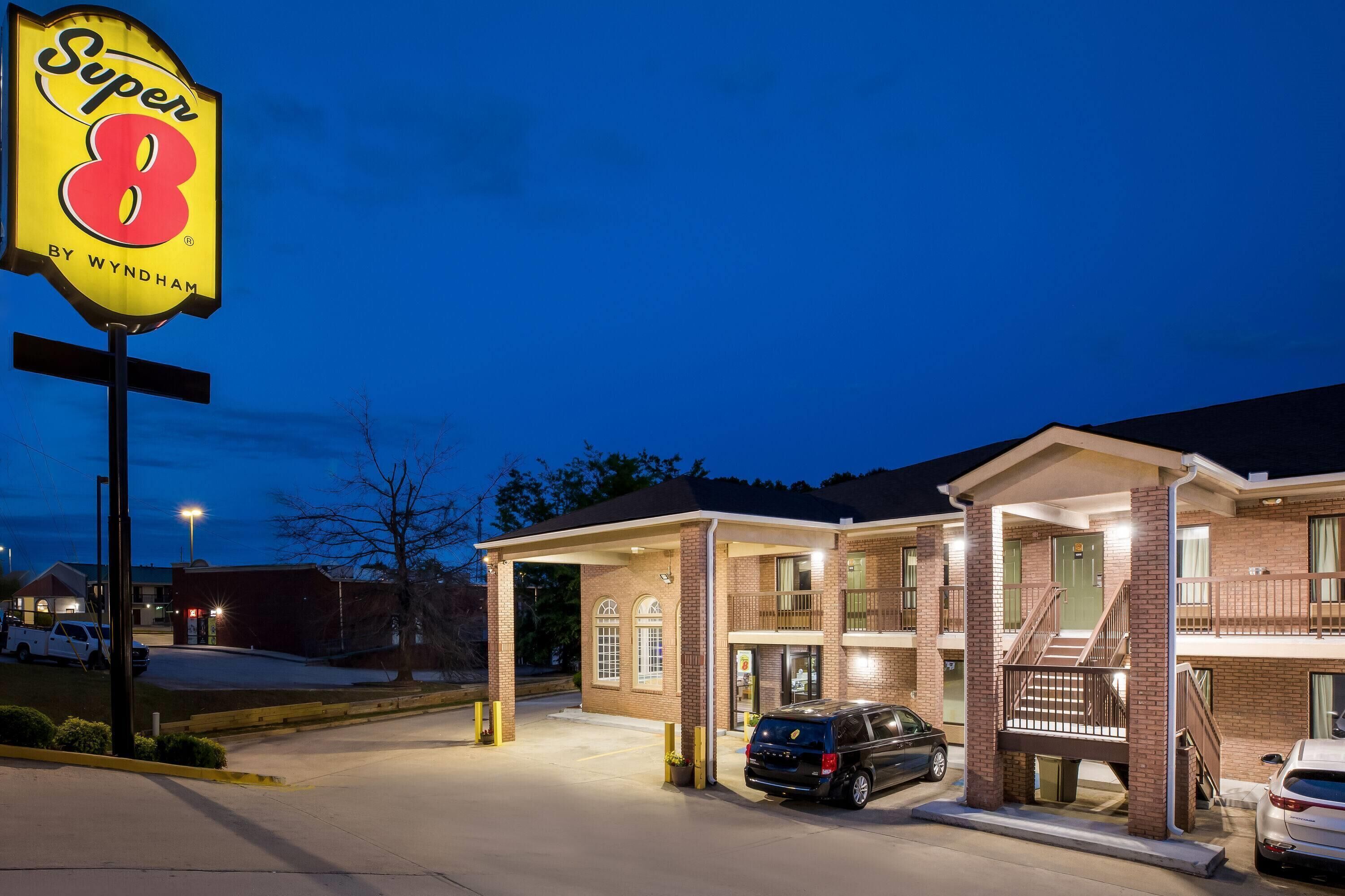 A hotel with a prominent 'Super 8' sign, a covered parking area, and a brick facade.