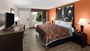 A hotel room with a bed, desk, TV, and two lamps. - Super 8 by Wyndham Bulls Gap Greeneville Area (Bulls Gap)