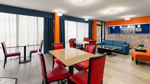 A modern hotel room with a dining area, a sofa, and a kitchen area. - Super 8 by Wyndham Bulls Gap Greeneville Area (Bulls Gap)