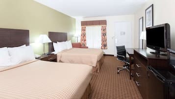 Une chambre d’hôtel avec deux lits, un bureau équipé d’une télévision, une chaise et une lampe de bureau.