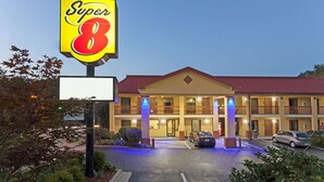 A Super 8 hotel with a two-story structure, a red roof, and a parking lot with cars. - Super 8 by Wyndham Decatur/Dntn/Atlanta Area (Decatur)