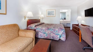 A hotel room with a bed, a sofa, a desk, and a TV. - Knights Inn Columbia (Columbia)