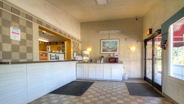 A clean, well-lit kitchen area with white cabinets, a checkered floor, and a 'No Smoking' sign.