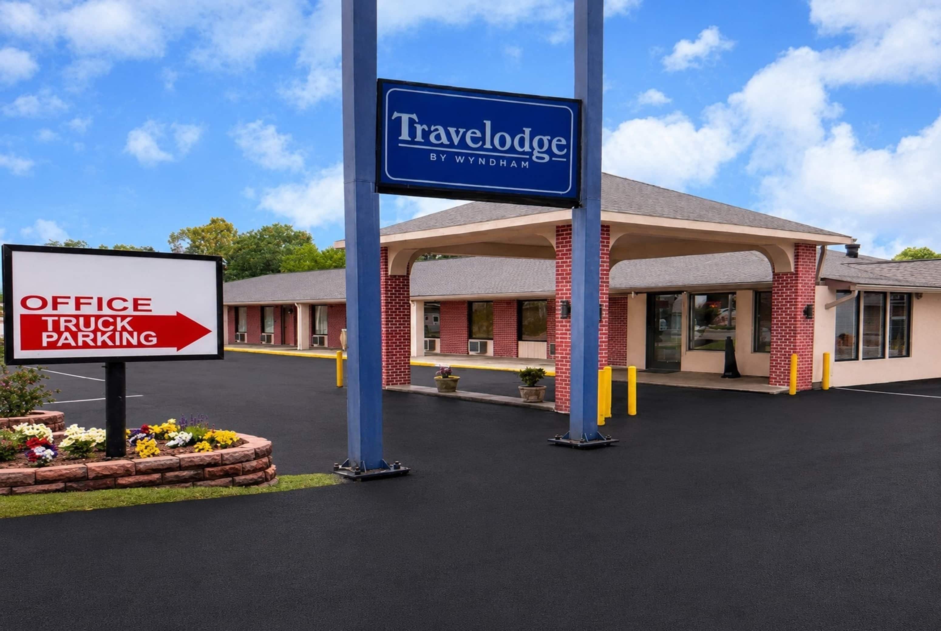 Hotel Travelodge com placa indicando estacionamento para escritório e caminhões.