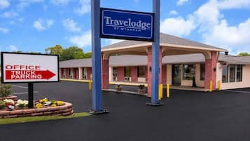 Un hotel Travelodge con un cartel que indica aparcamiento para oficinas y camiones.