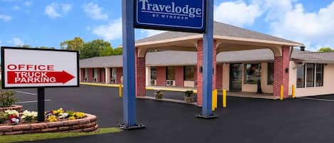 Un hotel Travelodge con un cartel que indica aparcamiento para oficinas y camiones.
