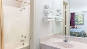 Ein Badezimmer mit Badewanne, Waschbecken und Spiegel.
