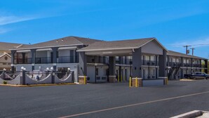 A motel with a two-story structure, a covered parking area, and a clear sky. - Super 8 by Wyndham Waco North I-35 (Waco)