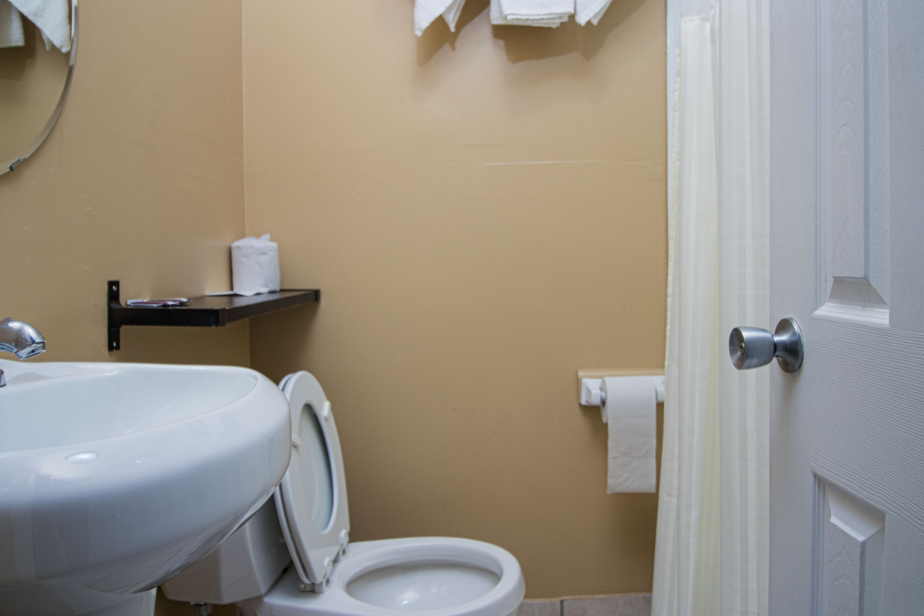 A bathroom with a sink, toilet, and a towel rack.