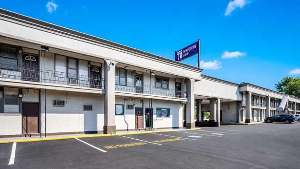 A Knights Inn with a two-story building, a signboard, and a parking lot with marked spaces.