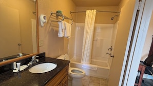 Un baño con lavamanos, inodoro y zona de ducha.