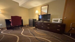 A hotel room with a flat-screen TV, a microwave, a dresser, and a red chair. - Super 8 by Wyndham Normal Bloomington (Normal)