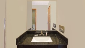 A bathroom with a black granite sink, a mirror, and a ceiling light. - Super 8 by Wyndham Normal Bloomington (Normal)