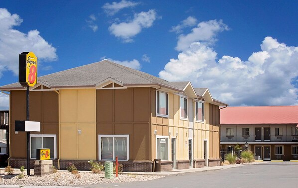 Un motel à deux étages, avec une façade de couleur beige et un toit rouge.