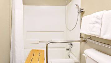 A bathroom with a shower, a grab bar, a wooden bench, and a towel rack.