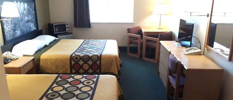 A hotel room with two beds, a desk, a chair, a TV, a lamp, and a window with curtains.