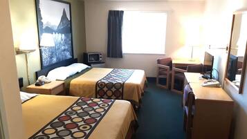A hotel room with two beds, a desk, a chair, a TV, and a window with curtains.