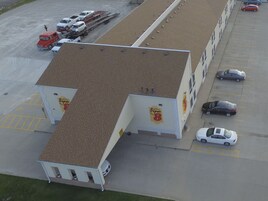 Un motel Super 8 con estacionamiento, un camión de bomberos y varios automóviles.