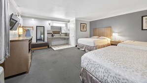 Ein Hotelzimmer mit einem Bett, einem Schreibtisch, einem Spiegel, einem Schminktisch und einem Fernseher.
