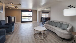 A spacious lobby with a sofa, chairs, a round table, and a TV. - Comfort Inn Hayward - Oakland South (Hayward)