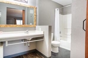 A bathroom with a white sink, mirror, and shower. - Infusion Beach Club (Palm Springs)