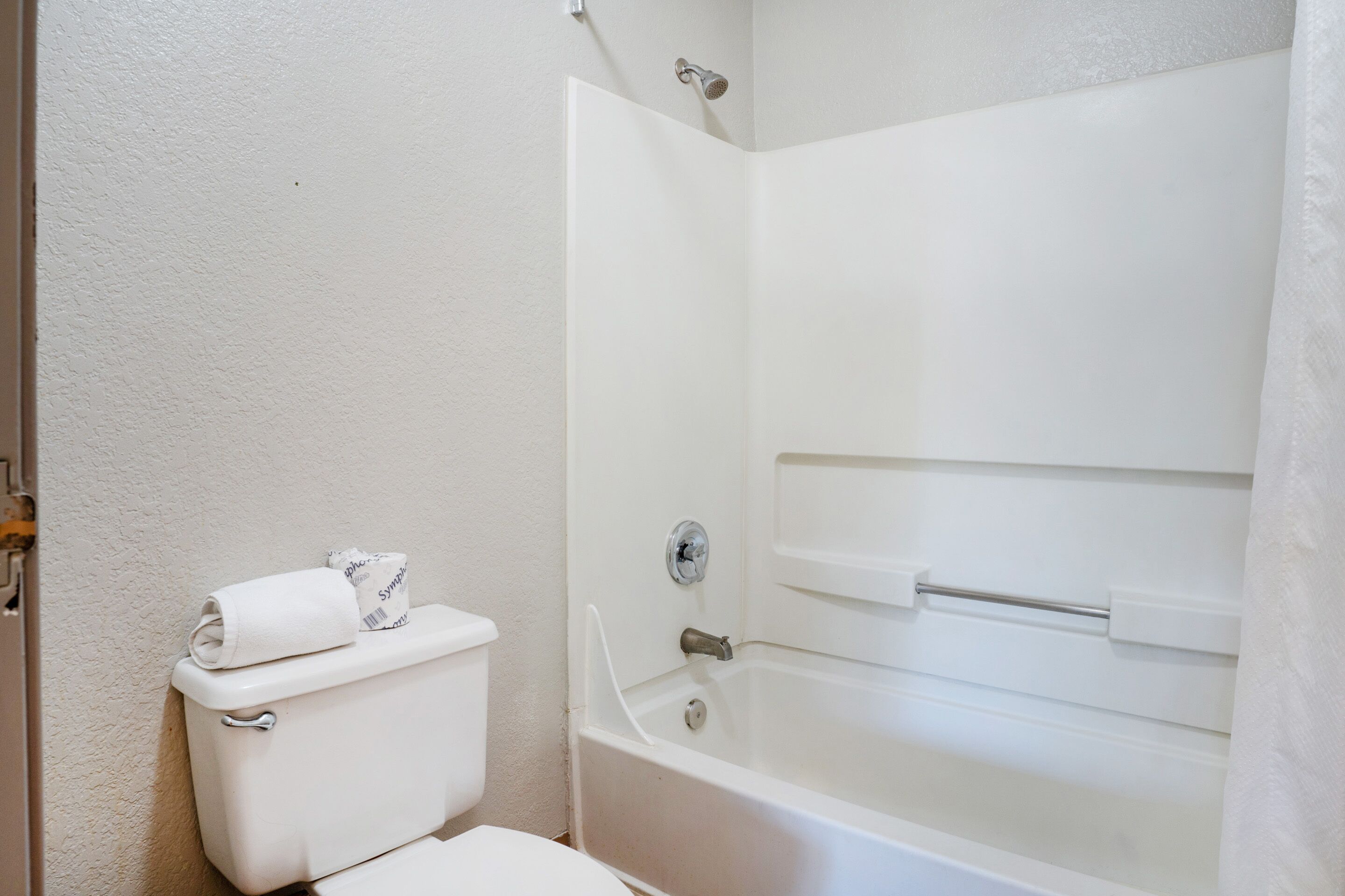 Un baño con inodoro, bañera y cortina de ducha.