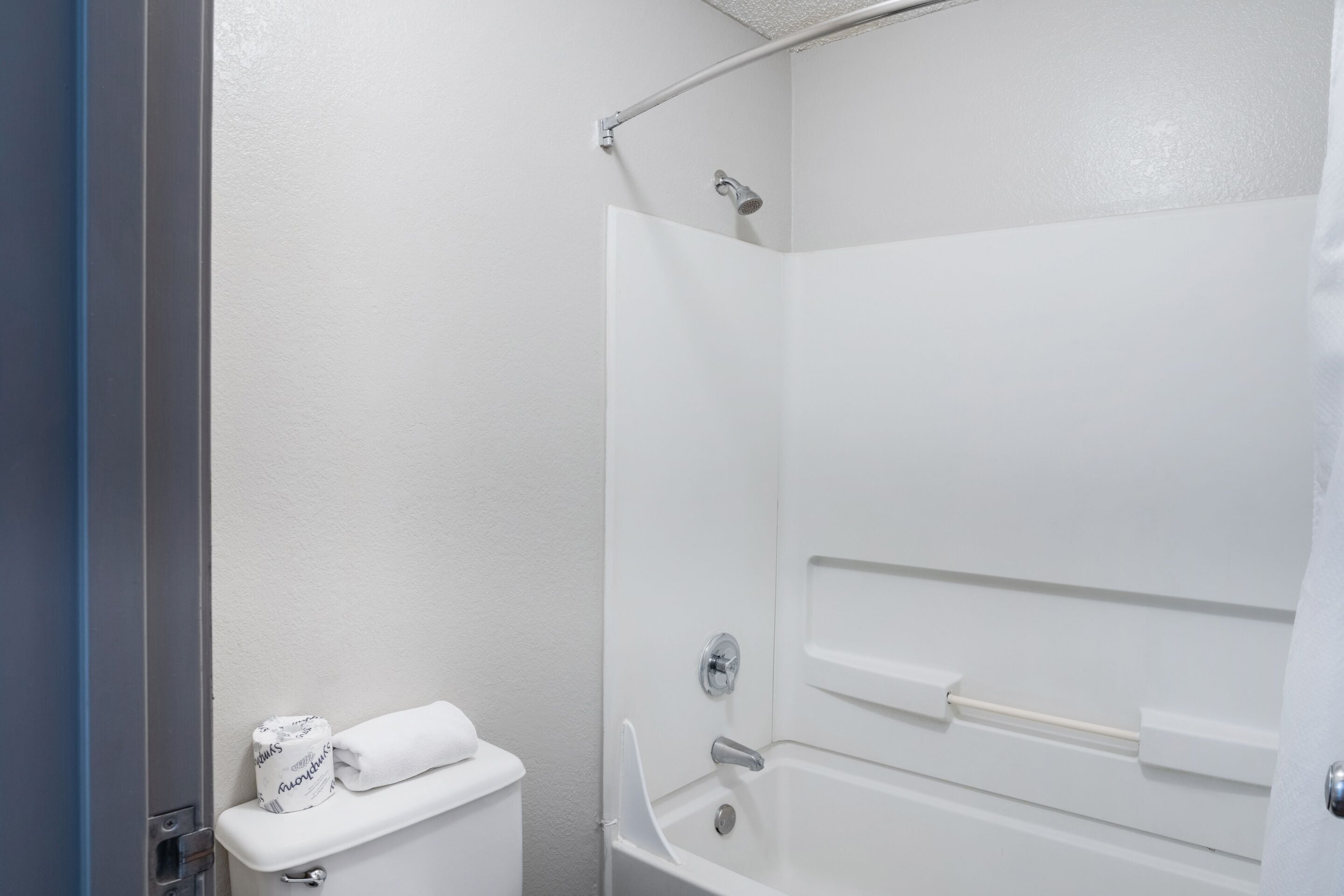 Ein Badezimmer mit Dusche, Toilette und Handtuchhalter.