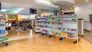 A spacious lobby with wooden flooring, a reception desk, and shelves stocked with snacks and beverages. - Inn at the Highland Denver Downtown (Denver)