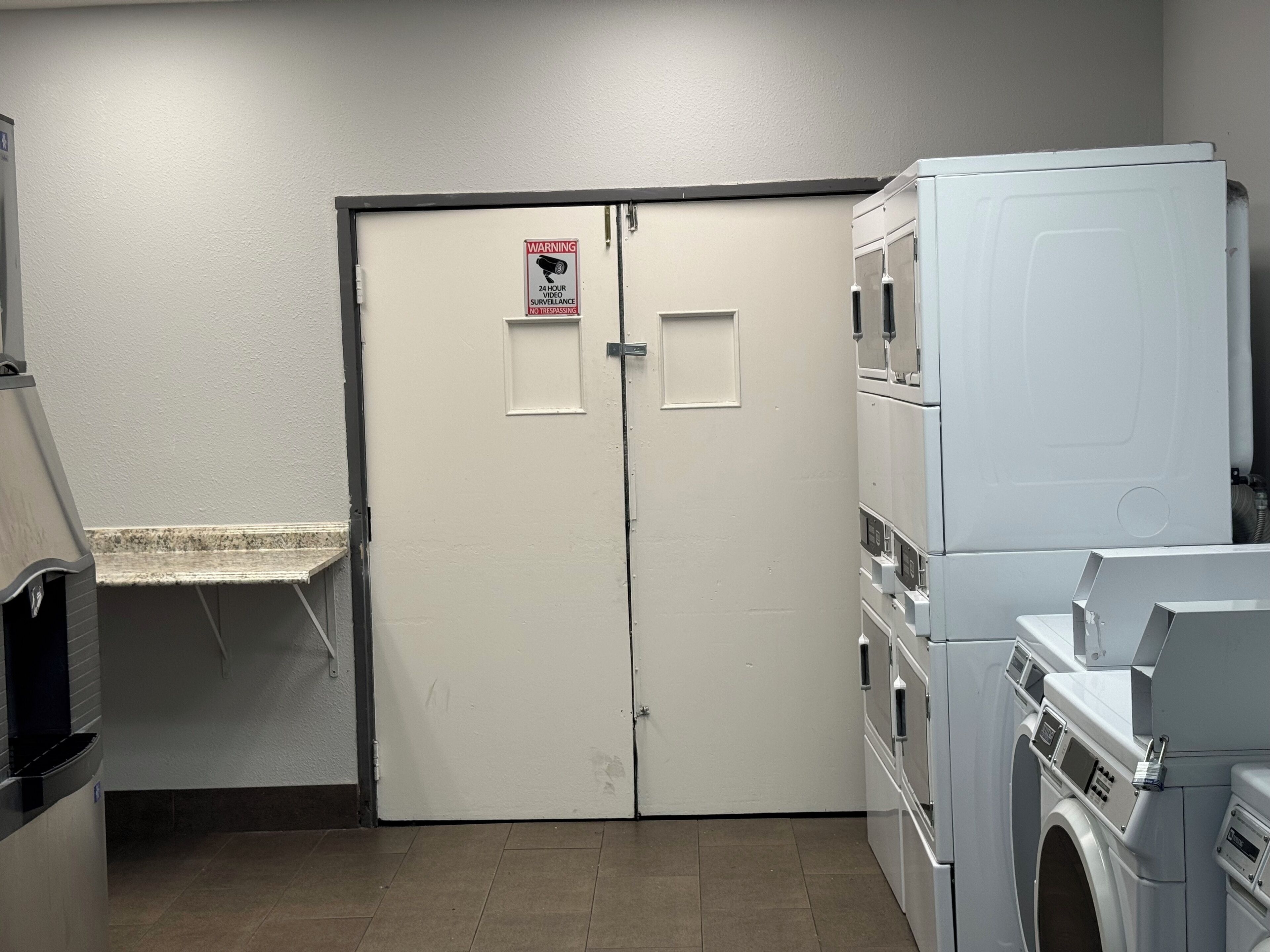 A laundry room with a double door, a washing machine, and a dryer.