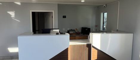 A modern kitchen with a central island, recessed ceiling lights, and a view of the adjacent living area.
